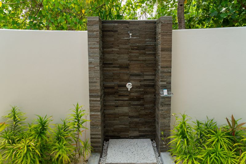 Open Shower with Stone Wall Accent